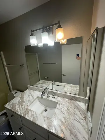 a bathroom with a granite countertop sink and a mirror