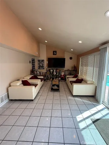 a living room with patio furniture and a flat screen tv