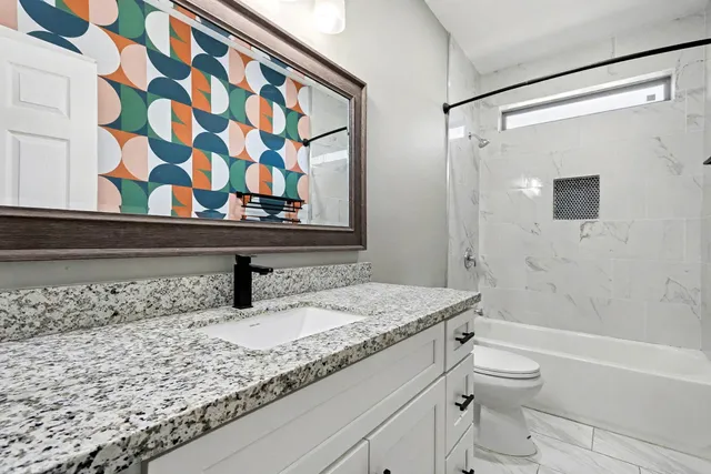 a bathroom with a granite countertop sink and a mirror