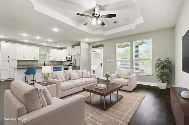a living room with furniture kitchen view and a large window