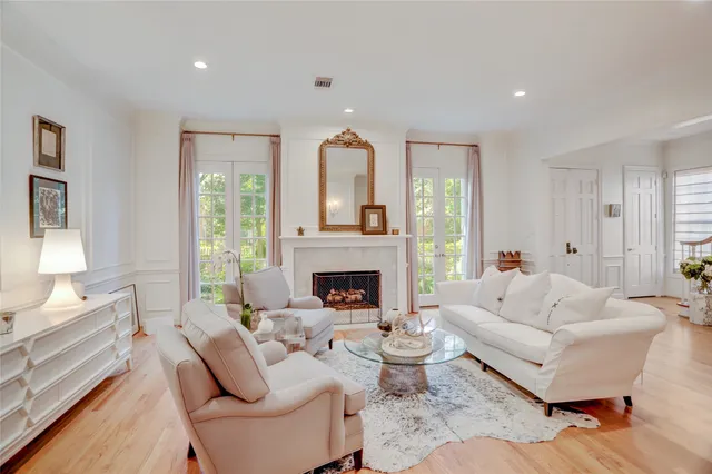 a living room with furniture a fireplace and a large window