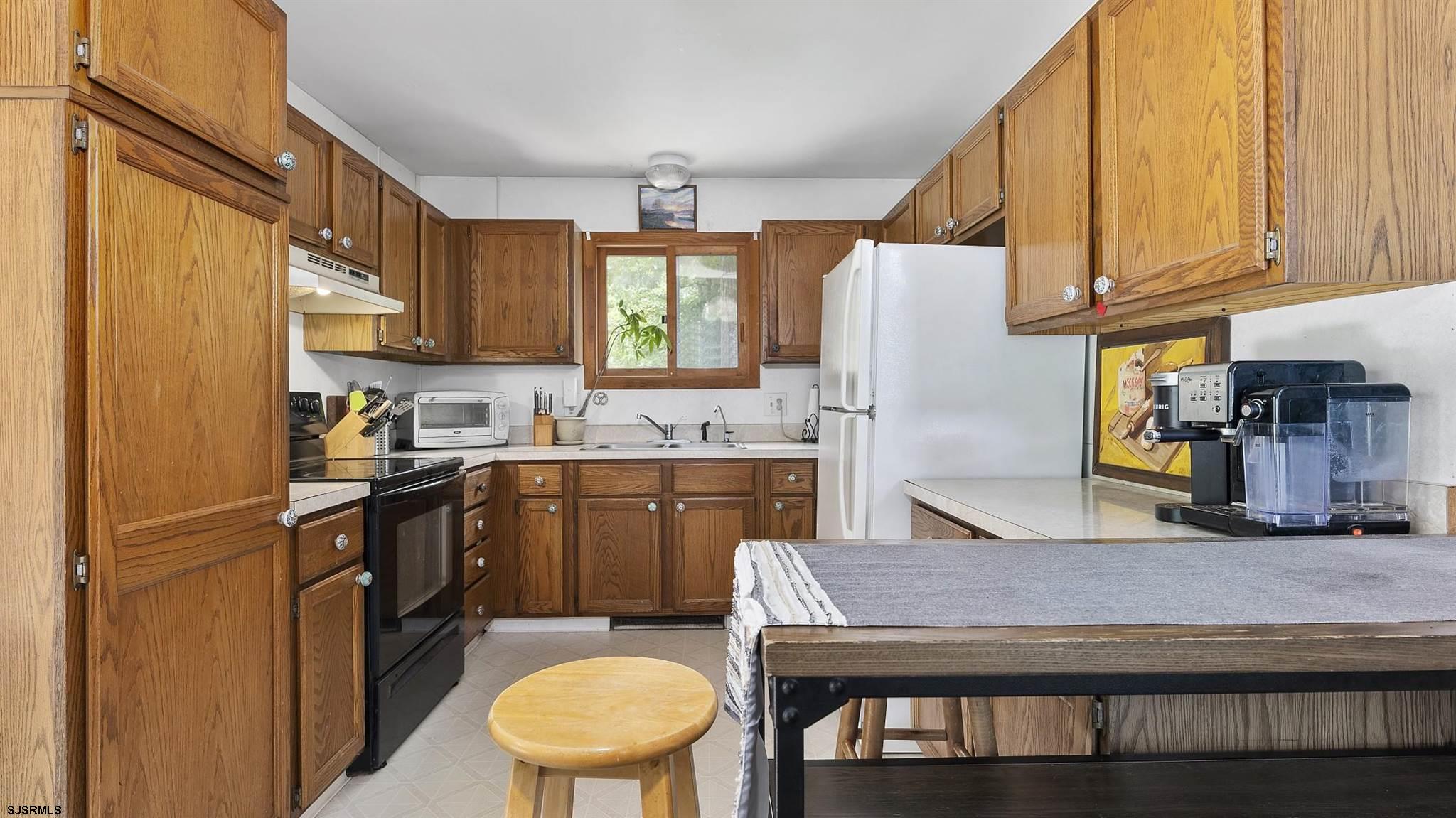 26 Indian Walk Road Ocean View, NJ 08230 - Photo 9 of 27 a kitchen with a refrigerator a stove a sink and cabinets