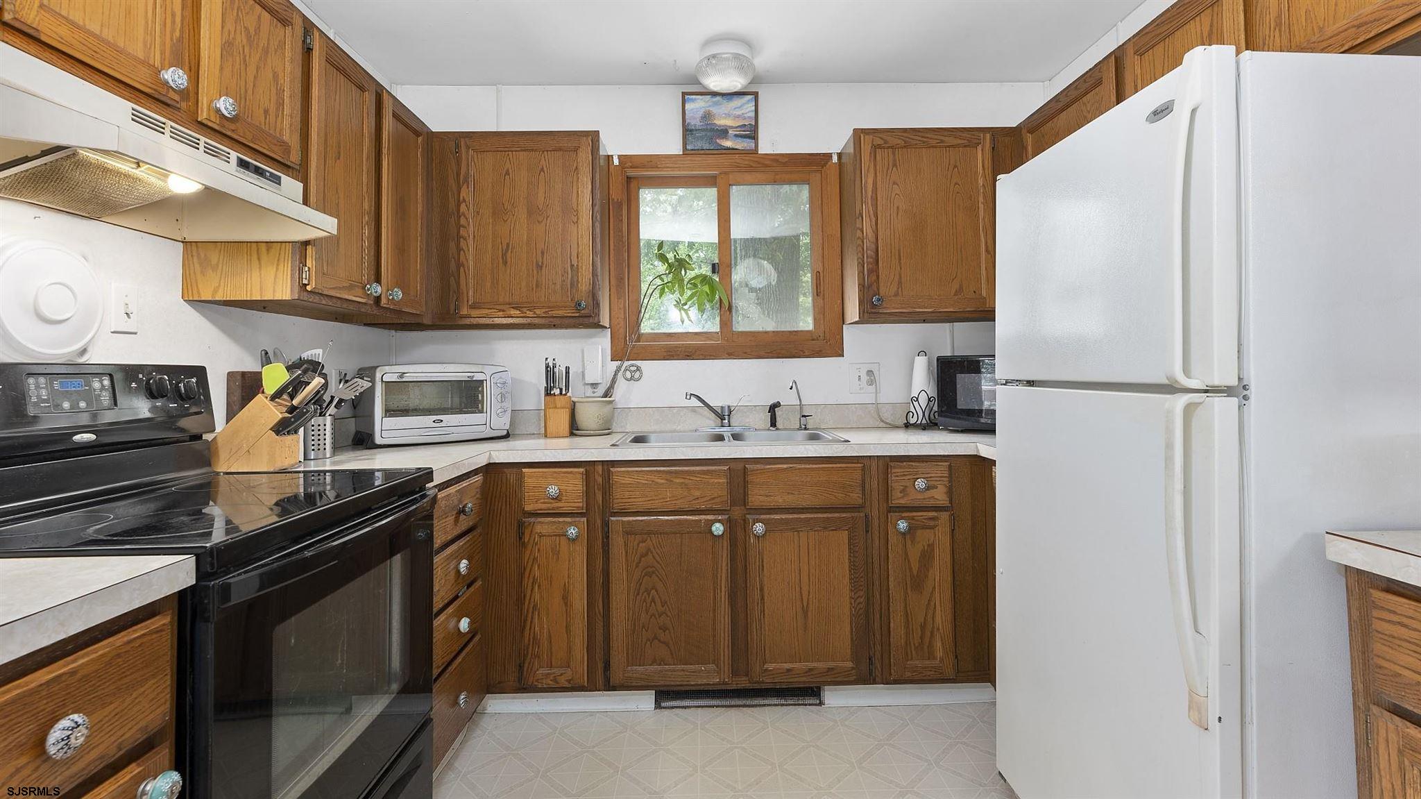 26 Indian Walk Road Ocean View, NJ 08230 - Photo 10 of 27 a kitchen with stainless steel appliances granite countertop a refrigerator a sink dishwasher a stove and white countertops with cabinets