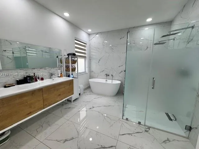 a bathroom with a granite countertop sink mirror and bathtub