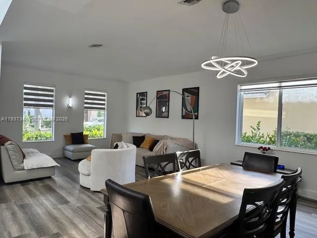 a view of a dining room with furniture wooden floor and a chandelier