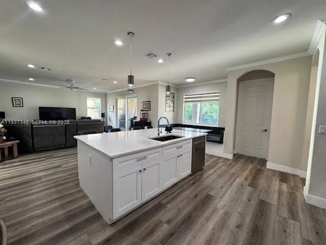 a large kitchen with stainless steel appliances kitchen island a large counter top a sink a stove and a refrigerator