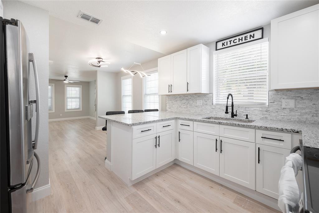 922 Delaware Avenue St. Cloud, FL 34769 - Photo 10 of 31 a kitchen with a sink cabinets stainless steel appliances and windows