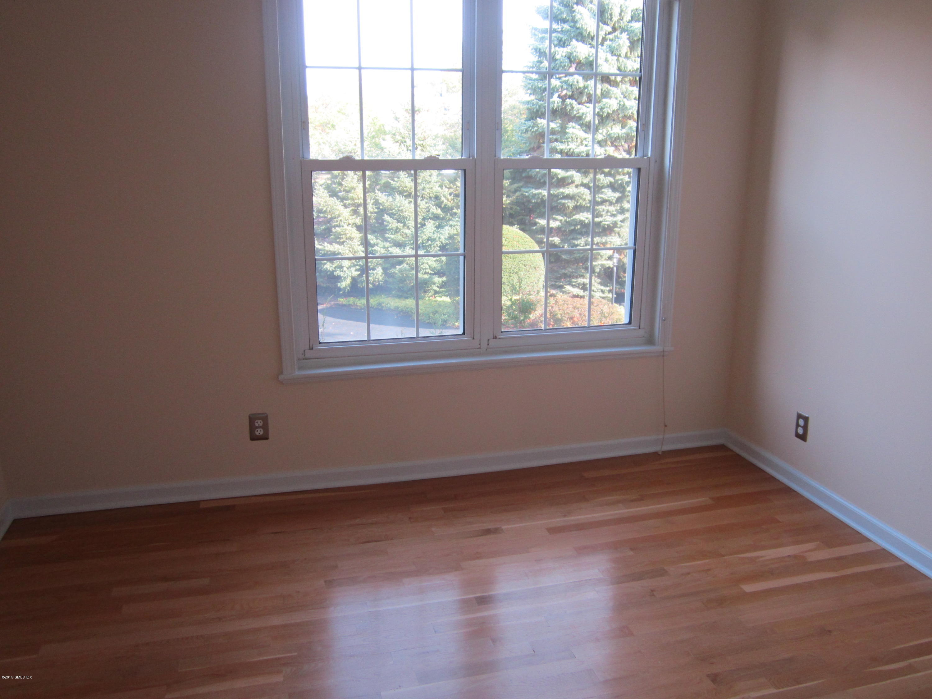 140 Field Point Road, Unit 21 Greenwich, CT 06830 - Photo 11 of 12 an empty room with wooden floor and windows