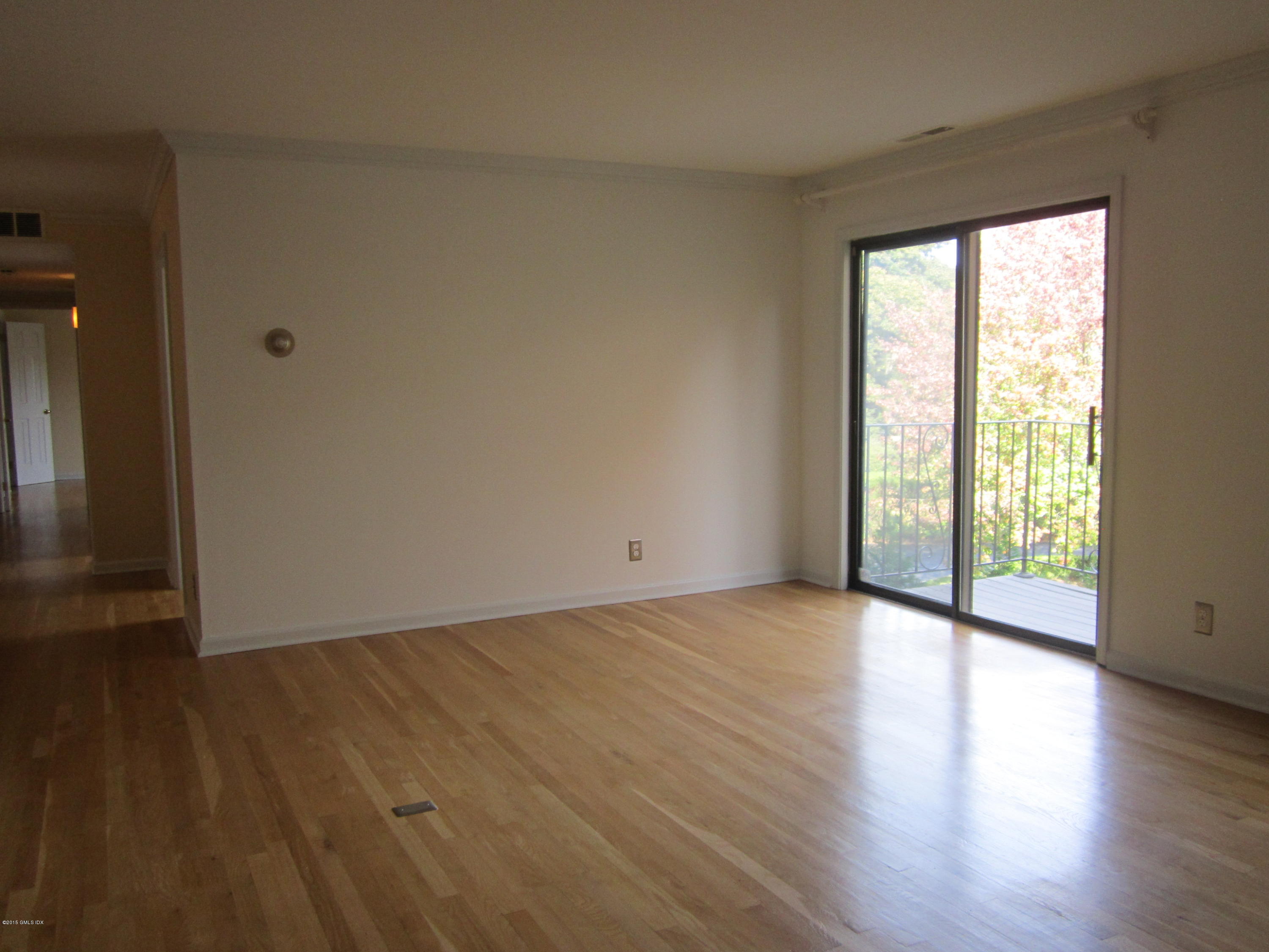 140 Field Point Road, Unit 21 Greenwich, CT 06830 - Photo 2 of 12 a view of an empty room with wooden floor and a window