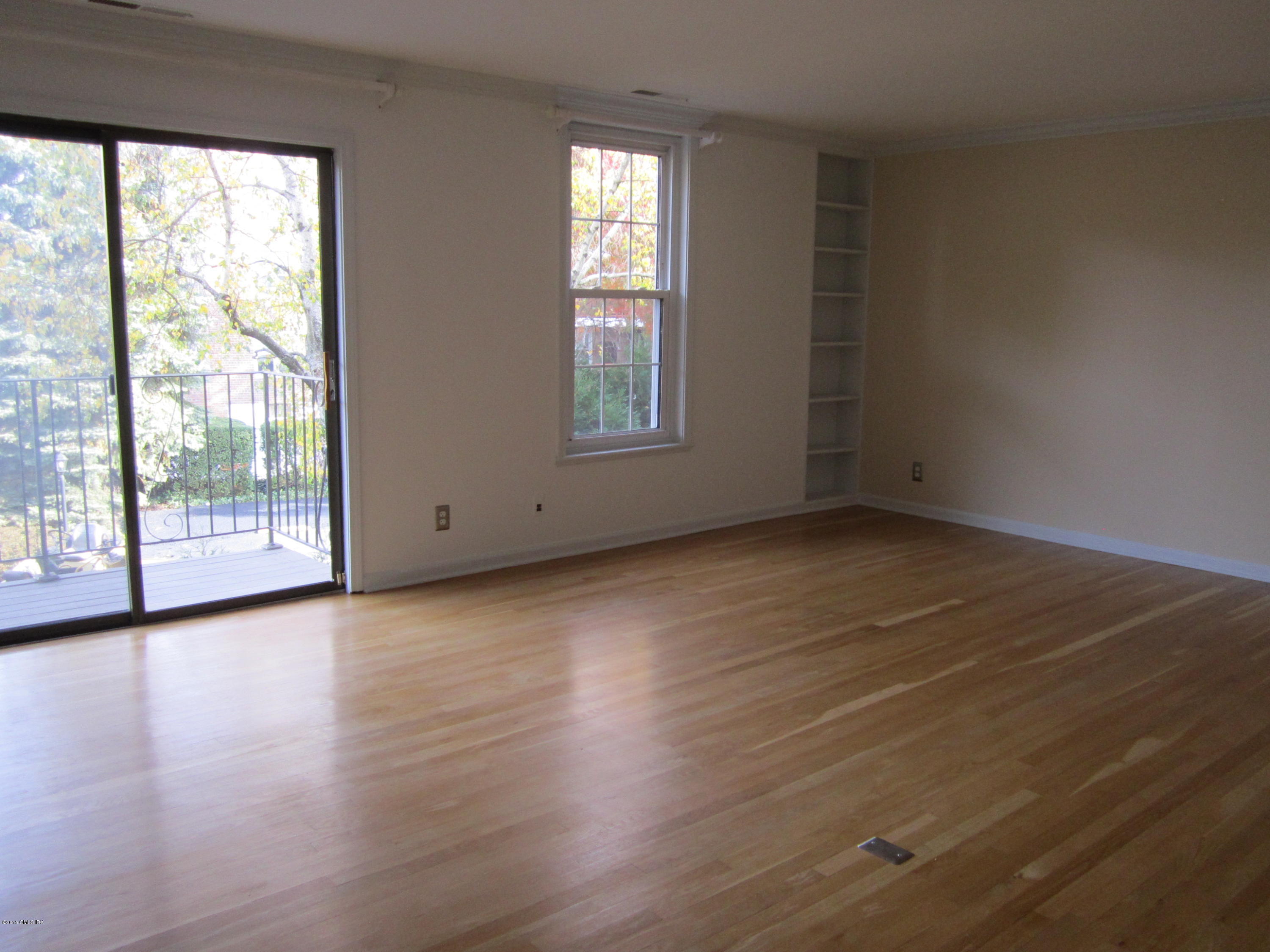 140 Field Point Road, Unit 21 Greenwich, CT 06830 - Photo 3 of 12 an empty room with wooden floor and windows