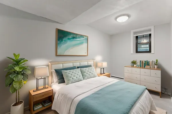 a bedroom with a bed and a potted plant