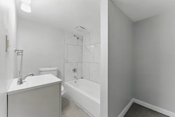 a bathroom with a tub sink and mirror