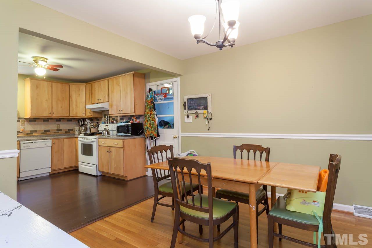 1733 Euclid Road Durham, NC 27713 - Photo 7 of 25 a kitchen with granite countertop white cabinets stainless steel appliances and dining table
