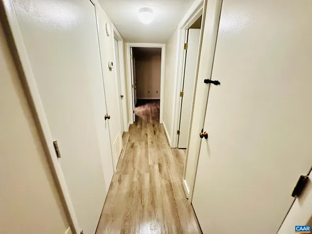 a view of a hallway with wooden floor and staircase