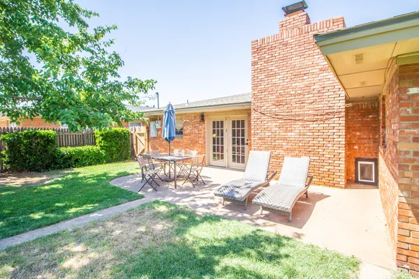 a view of a patio with a table chairs and a backyard