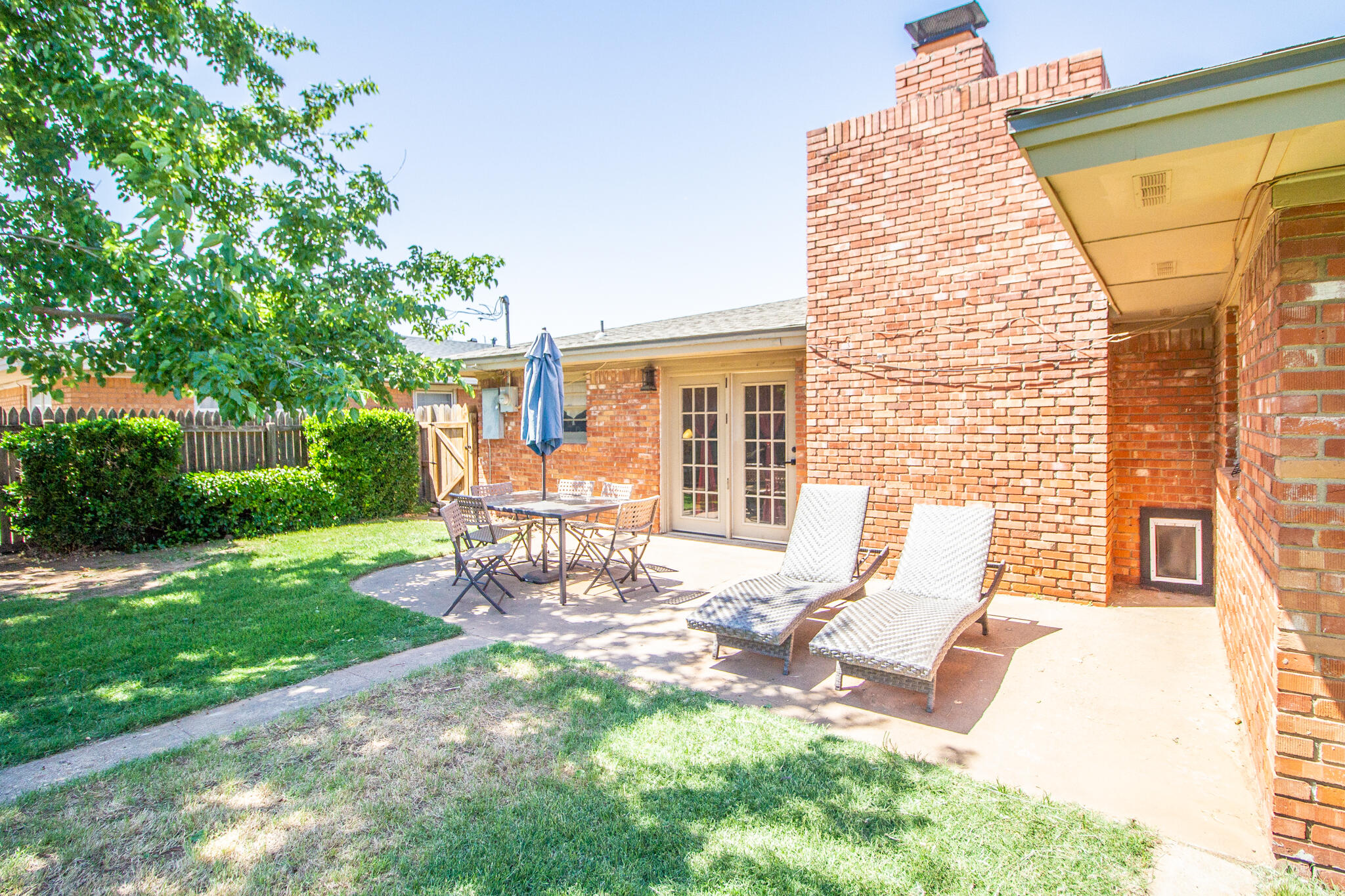 5219 9th Street Lubbock, TX 79416 - Photo 12 of 23 a view of a patio with a table chairs and a backyard