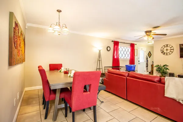 a living room with furniture a dining table and a chandelier