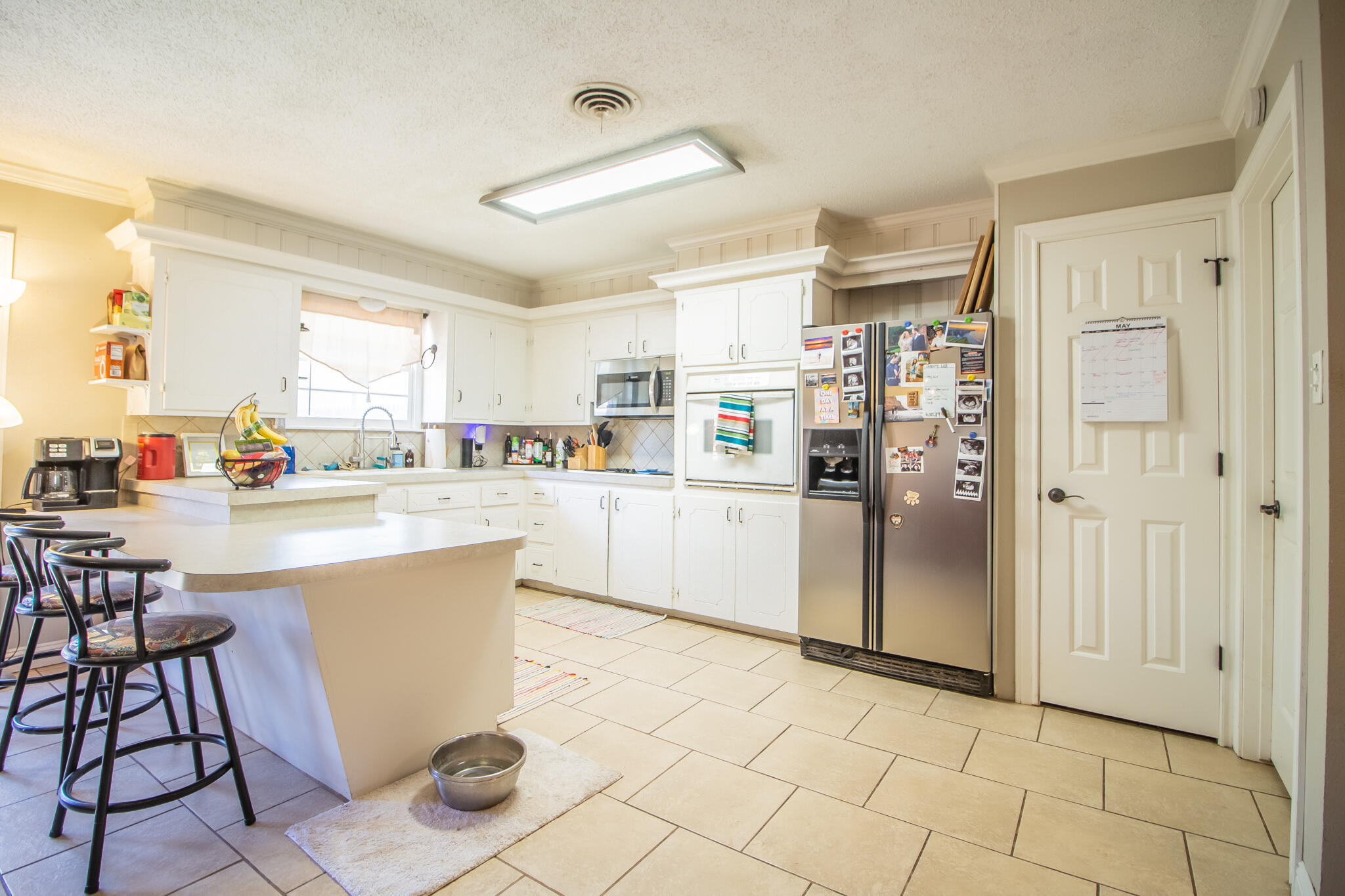 5219 9th Street Lubbock, TX 79416 - Photo 21 of 23 a kitchen with stainless steel appliances kitchen island granite countertop a refrigerator and a stove top oven