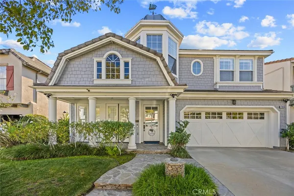 a front view of a house with a garden and plants