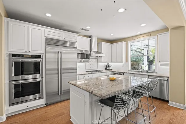 a kitchen with stainless steel appliances granite countertop a stove refrigerator sink and microwave