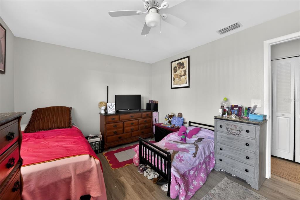 4154 16th Street East, Unit 15 Ellenton, FL 34222 - Photo 21 of 31 a bedroom with a bed and dresser with television