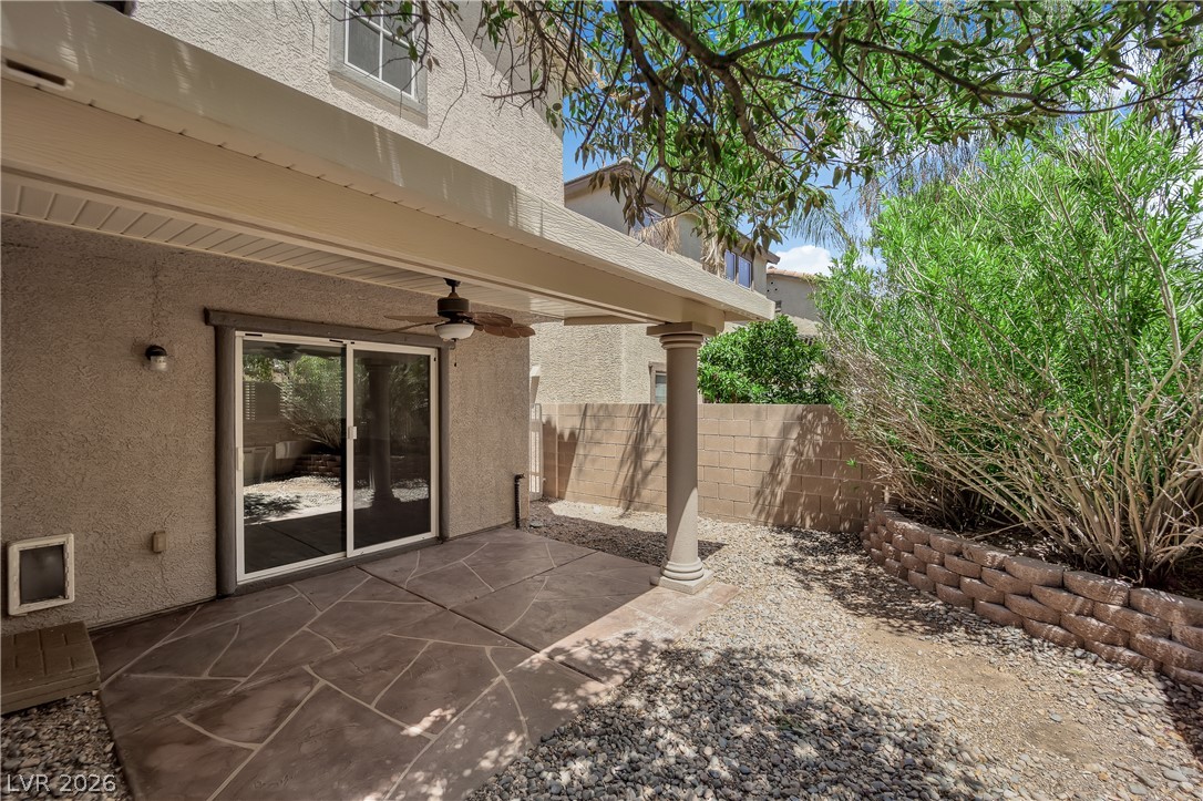 646 Monument Point Street Henderson, NV 89002 - Photo 30 of 44 A spacious covered patio with stamped concrete flooring and a ceiling fan extends to a landscaped yard.