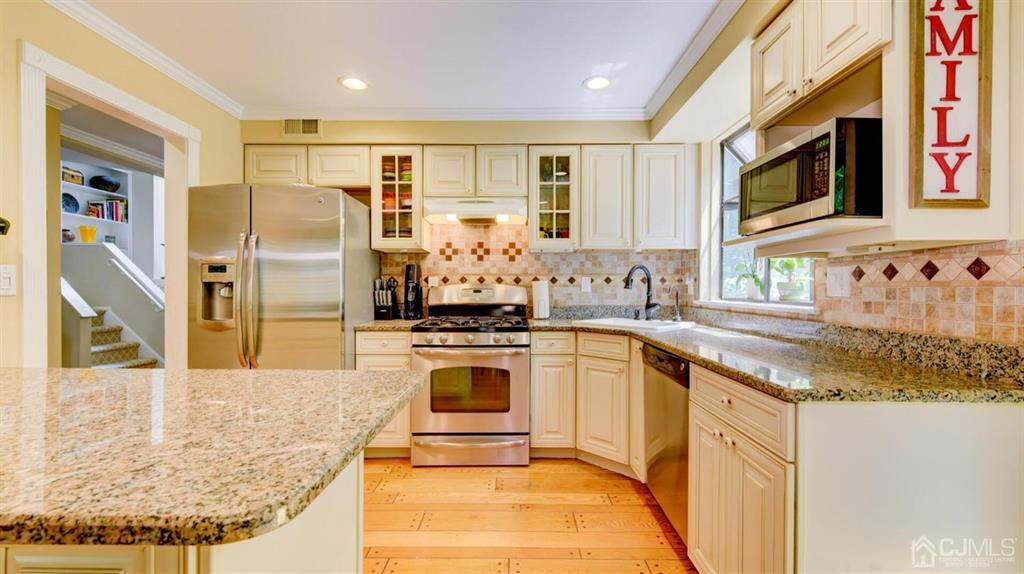449 Sayre Drive Plainsboro, NJ 08540 - Photo 21 of 58 a kitchen with stainless steel appliances granite countertop a sink stove and refrigerator