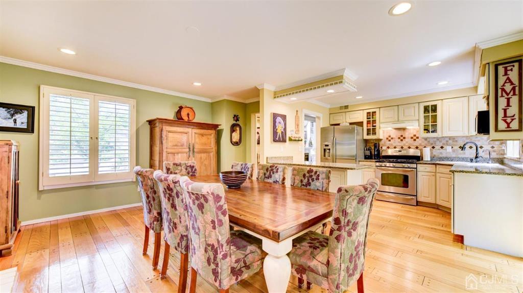 449 Sayre Drive Plainsboro, NJ 08540 - Photo 31 of 58 a dining room with stainless steel appliances kitchen island granite countertop a dining table chairs and granite counter tops