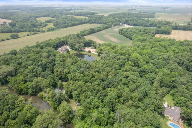 an aerial view of a houses with outdoor space and trees