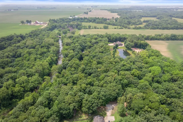 an aerial view of a houses with outdoor space and trees
