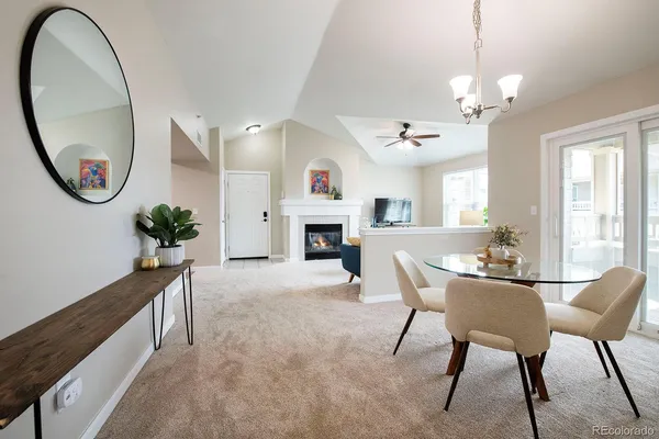 a view of a livingroom with furniture a fireplace and chandelier