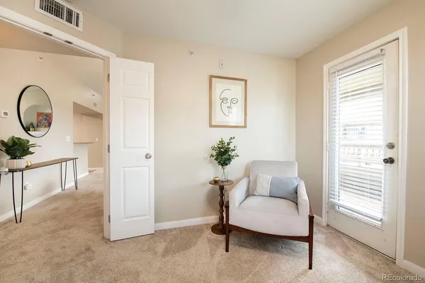 a living room with furniture a window and a potted plant
