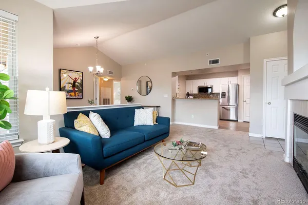 a living room with furniture and a dining table with kitchen view