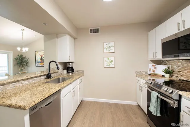 a kitchen with stainless steel appliances granite countertop a sink stove and microwave