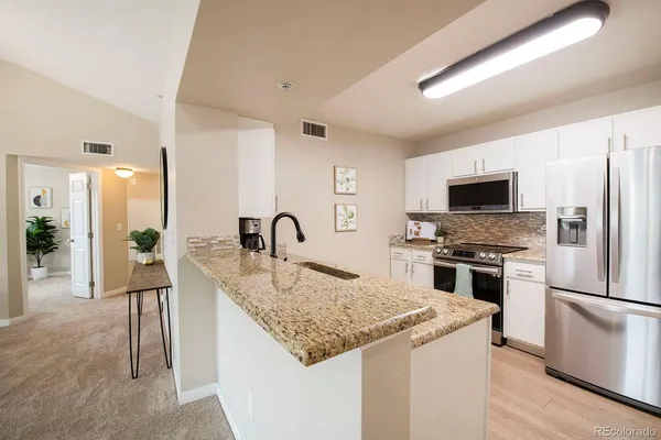 a kitchen with granite countertop a stove and a kitchen island