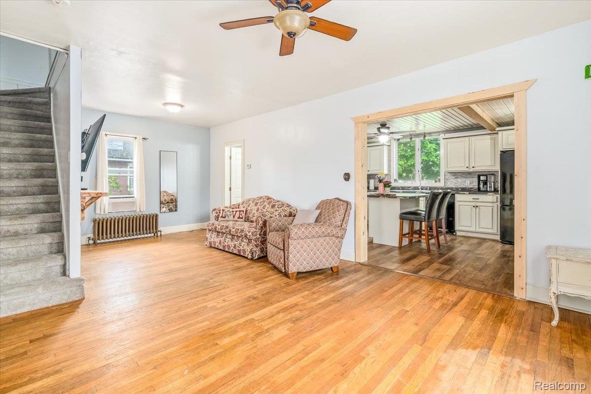 36940 Goddard Road Romulus, MI 48174 - Photo 3 of 31 Living room featuring light wood finished floors, radiator, and ceiling fan