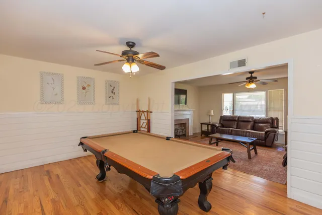 a living room with furniture pool table and a window