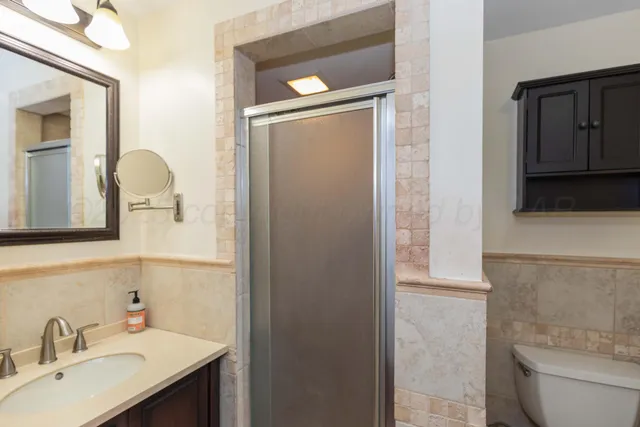 a bathroom with a sink a toilet and shower