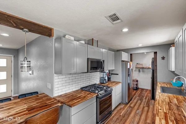 a kitchen with a sink a counter top space stainless steel appliances and a window