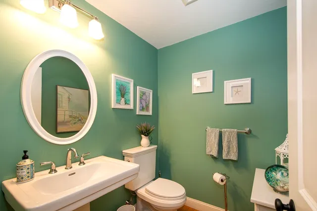 a bathroom with a toilet a sink and mirror