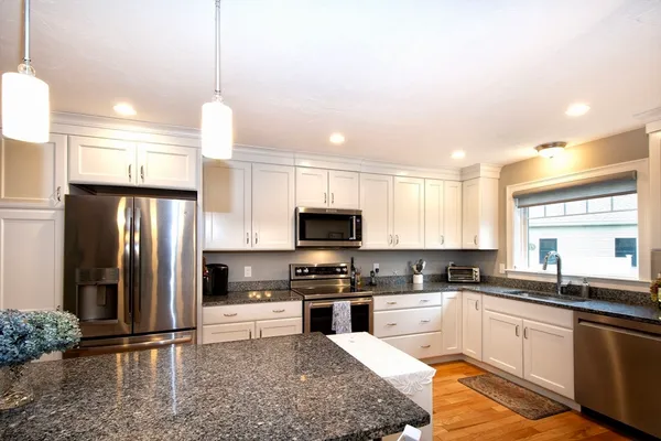 a kitchen with granite countertop a refrigerator and a sink