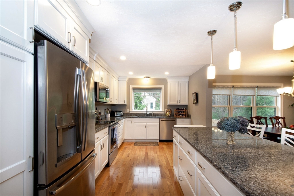18 Kevin's Way, Unit 18 Scituate, MA 02066 - Photo 9 of 33 a large kitchen with kitchen island a large counter top space a sink stainless steel appliances and cabinets
