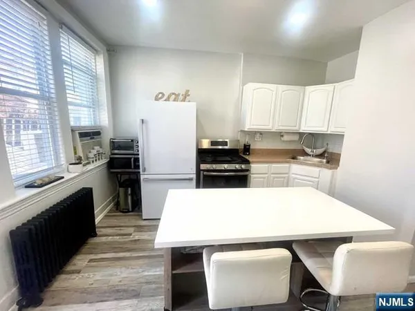 a kitchen with a refrigerator a stove a sink dishwasher with a dining table and chairs