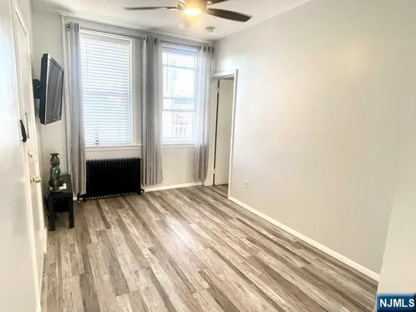 a view of a bedroom with wooden floor and a window
