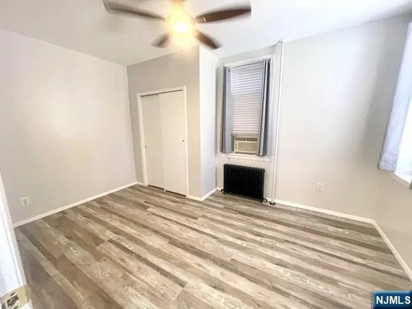 a view of a room with wooden floor and a ceiling fan