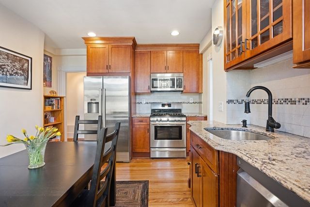 a kitchen with stainless steel appliances granite countertop a sink a stove and a refrigerator