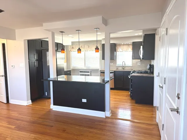 a view of kitchen with stainless steel appliances granite countertop a refrigerator and a sink