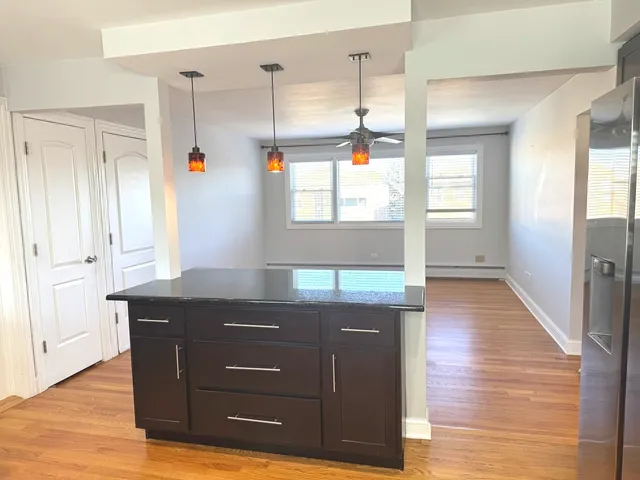 a kitchen with granite countertop wooden cabinets and wooden floor
