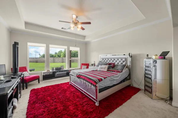 a room with a bed a flat screen tv and a larger window