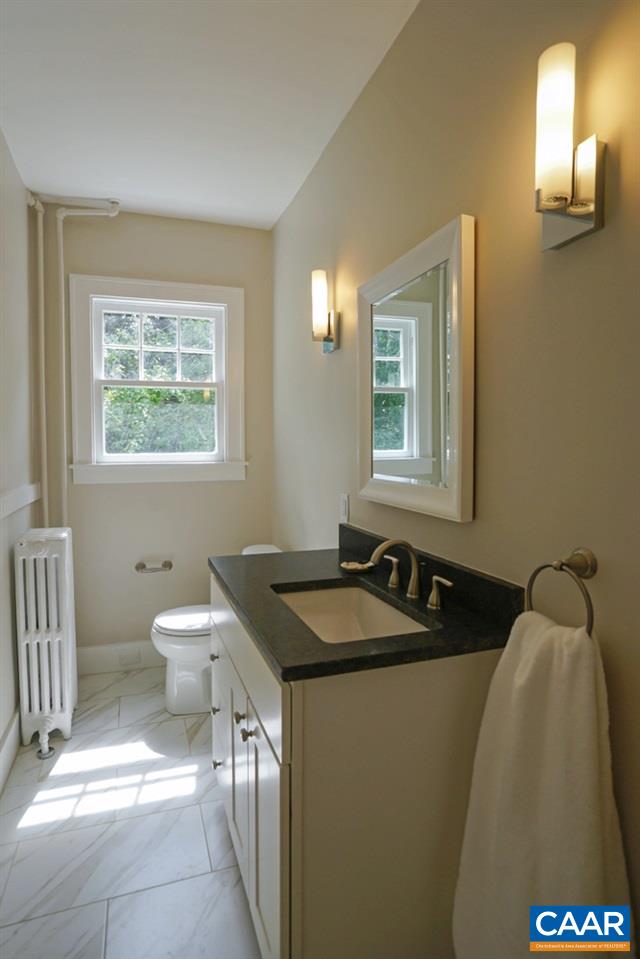 1930 Thomson Road Charlottesville, VA 22903 - Photo 14 of 35 a bathroom with a granite countertop sink a toilet and a window